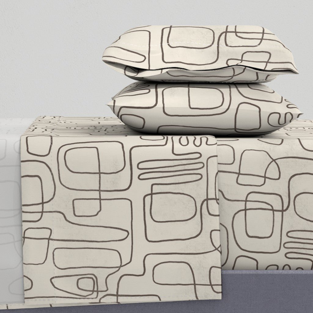 Patterned bedding set with pillows on a bed against a light gray background