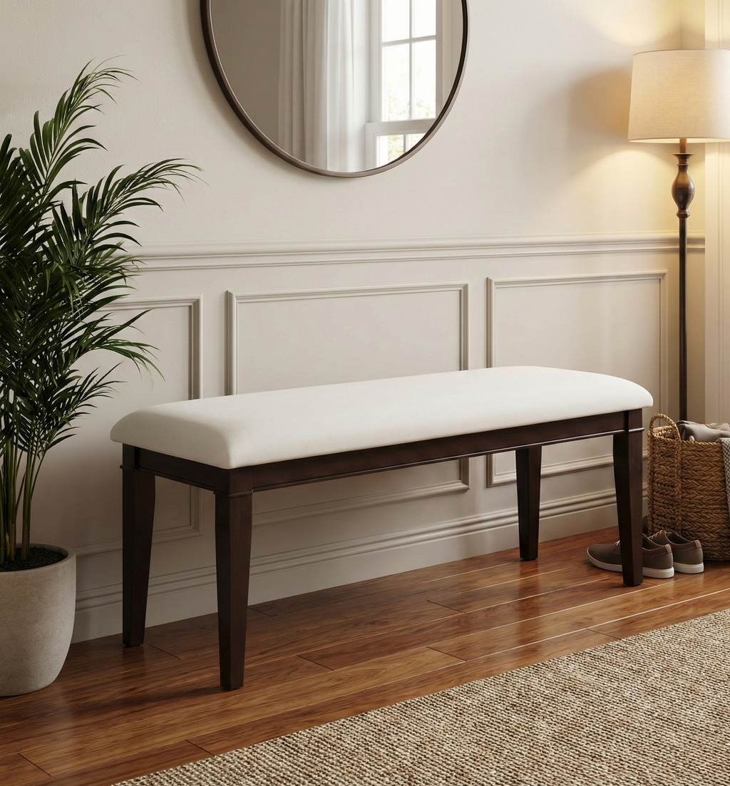 A long, dark wood bench with a white, upholstered cushion sits in the center of the image.