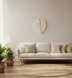 Beige sofa in a living room with decorative wall art and plants.
