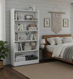 White bookshelf in a bedroom with books, decor items, and a bed.